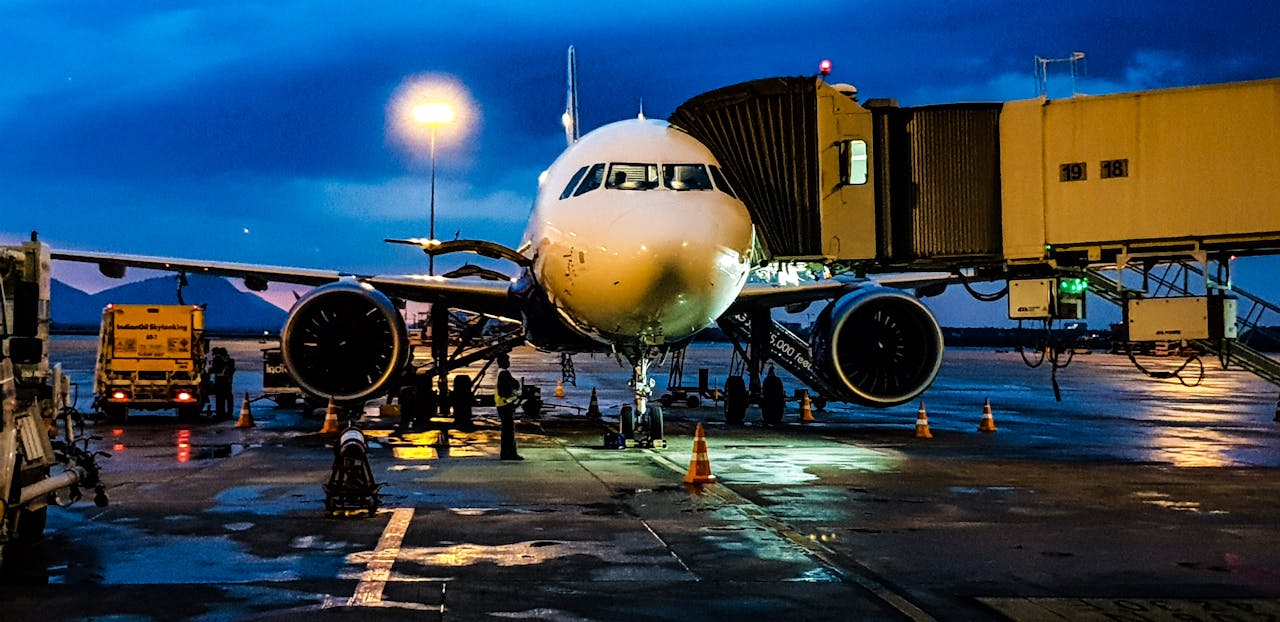 About A commercial airplane on the runway at Bengaluru airport during night with a blue sky backdrop.